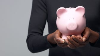 picture of a woman holding a pink piggy bank