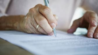 A person signs some documents.