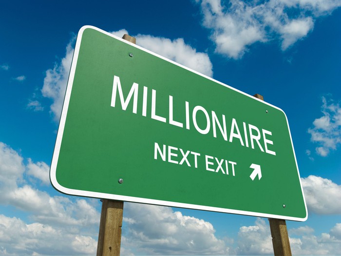 Green highway sign that reads Millionaire next exit