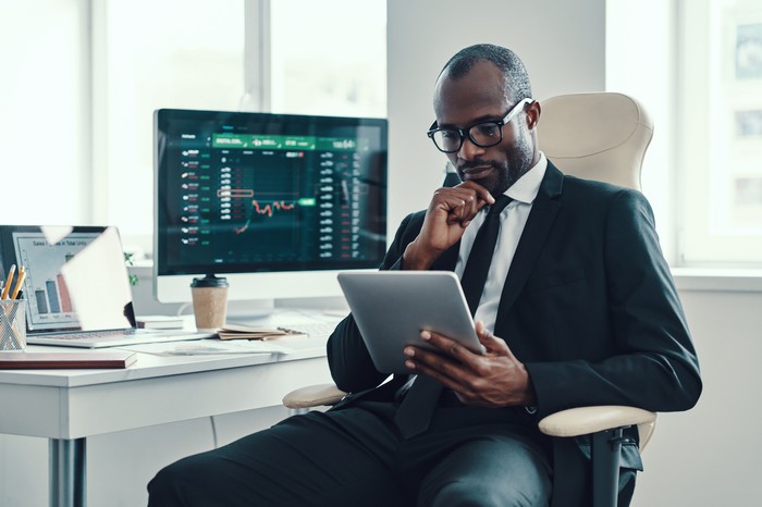 Investor looking at computer and charts.