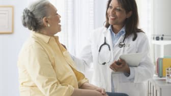 A doctor speaking with a woman during an exam