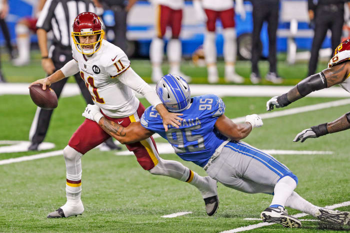 Alex Smith avoids a sack during a 2020 game against the Lions, his first start since his injury