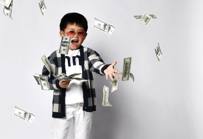 A kid throwing money around. 