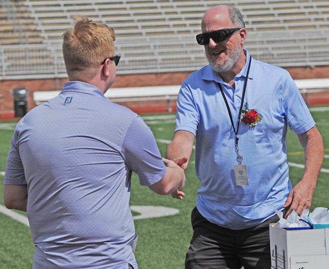 Gabe Grant, USD 305 School Board President, presents a retirement gift to Salina Central High School Band teacher Ben Rohrer during the retirement recognition ceremony at Salina Stadium on Sunday afternoon. Rohrer will be retiring after this school year and will have served 27 years for USD 305 Salina Public Schools. Rohrer plans to enjoy retirment by relaxing and making TikTok videos.