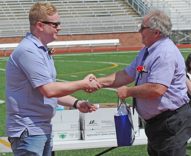 Gabe Grant, USD 305 School Board President, presents a retirement gift to Lonny Schropp, current Sunset Elementary School principal, after servicing 22 years to the Salina Public Schools.