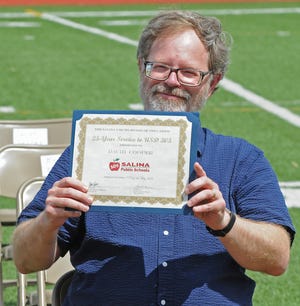 David Cooper, grant writer for USD 305, holds his 25-year service award certificate during the Salina schools USD 305 staff recognition ceremony at Salina Stadium on Sunday afternoon.