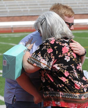 Cheryl Ritter hugs Gabe Grant, USD 305 School Board President, after receiving a retirement gift for service 41 years to the Salina Public Schools during the retirement recognition ceremony at Salina Stadium on Sunday afternoon.