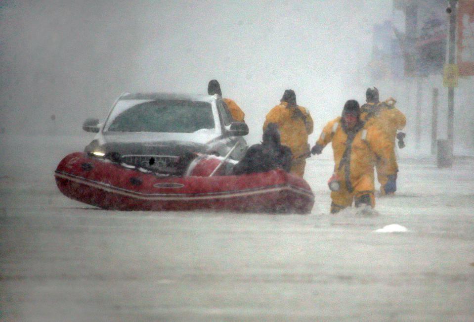 (010418 Boston, MA) Justin Plaza, at right, with Boston Fire Rescue pulls an inflatable boat as he and other firefighters save a man from his flooded car on Commercial Wharf during the storm on Thursday,January 4, 2018. Staff Photo by Nancy Lane
