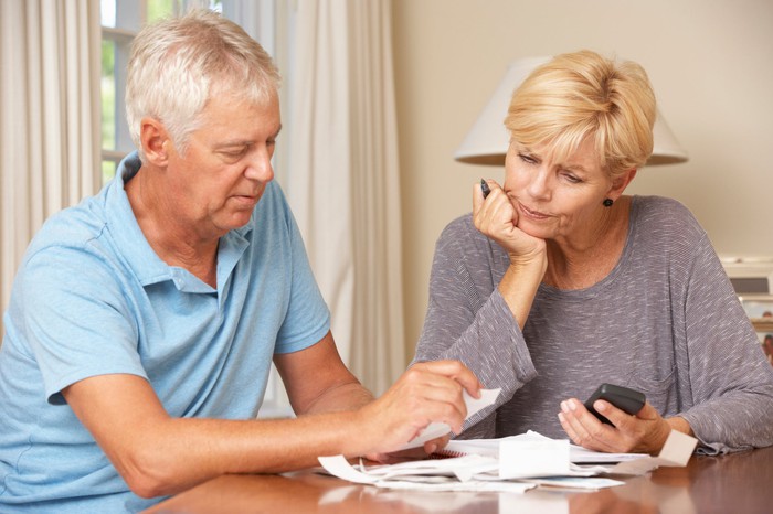 Two people with serious expressions looking at documents