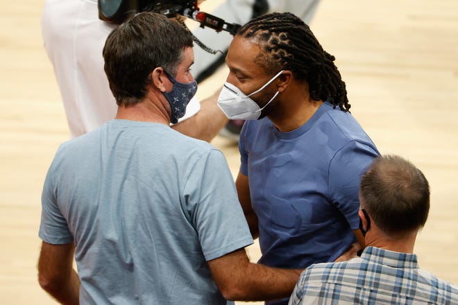 NFL player Larry Fitzgerald greets professional golfer Bubba Watson during Game 2 of the playoff series between the Phoenix Suns and Denver Nuggets at Phoenix Suns Arena on June 9.