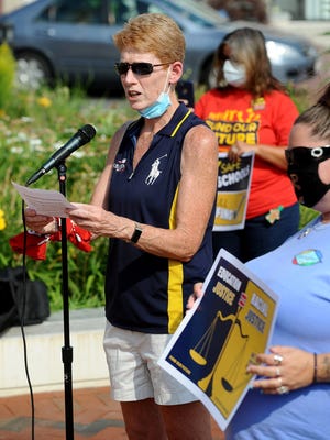 Framingham Teachers Association President Christine Mulroney speaks at a rally in front of City Hall Wednesday afternoon to speak out against proposed state budget cuts.