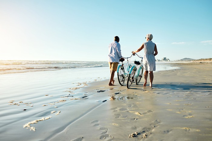 retired couple enjoying the view with bikes on the beach. 