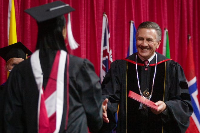 Grand View University President Kent Henning smiles as he shakes hands with 2021 graduates during commencement Monday, April 26, 2021 at Wells Fargo Arena. It was the 22nd commencement for Henning as Grand View president.