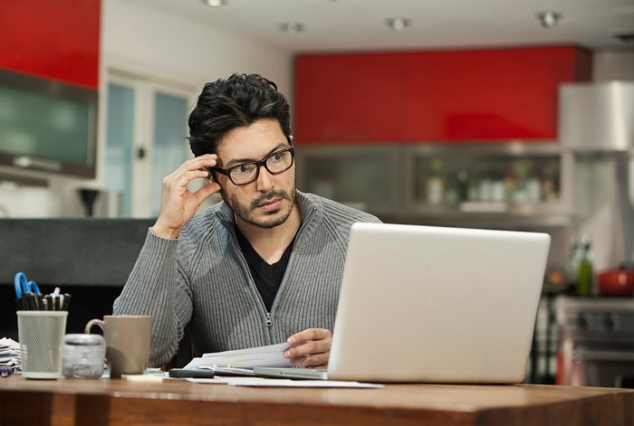 Person with serious expression at laptop.