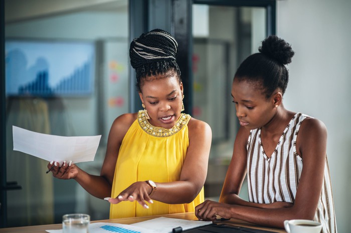 Two coworkers discussing a document.