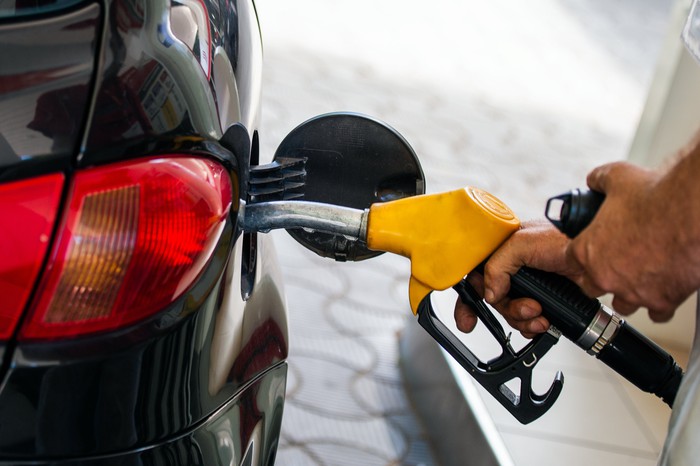 Pumping gasoline into a car.