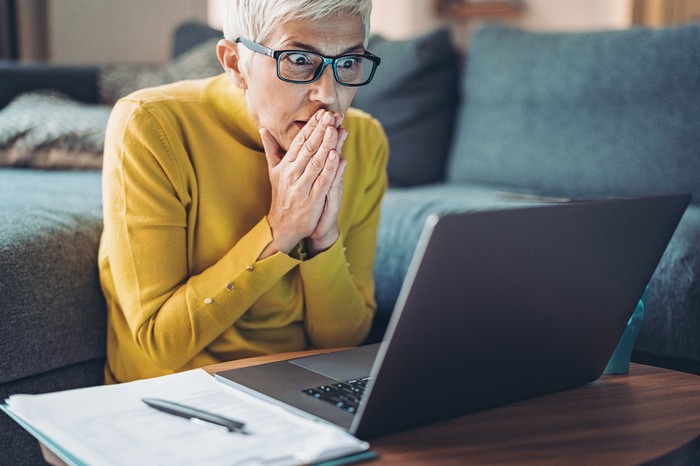 Person looking at laptop with shocked expression