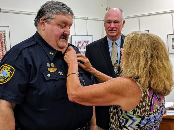 In this 2019 file photo, York Police Chief Charles Szeniawski receives his chief's pins from his wife, Mary-Anne Szeniawski, during a change of command ceremony at a York Board of Selectmen meeting as recently retired police chief Douglas Bracy looks on.  Charles Szeniawski was placed on paid administrative leave Wednesday, July 21, 2021, for reasons that had not been made public nearly a week later.